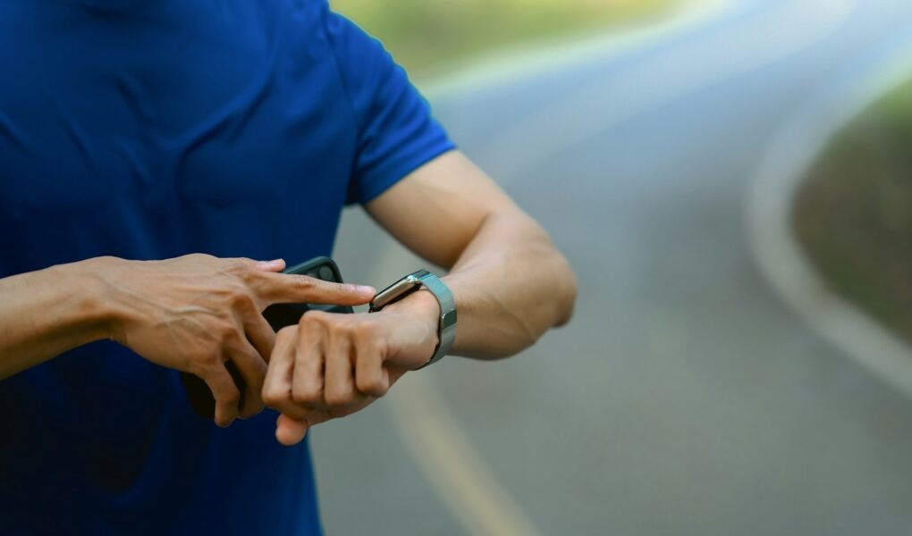Cropped shot of male runner checking smartwatch to monitor training results.